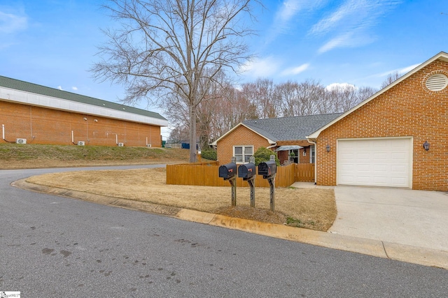 view of front of home with a shingled roof, concrete driveway, a fenced front yard, an attached garage, and brick siding