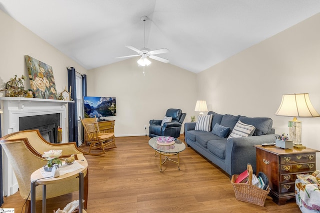 living room with a fireplace, wood finished floors, a ceiling fan, baseboards, and vaulted ceiling