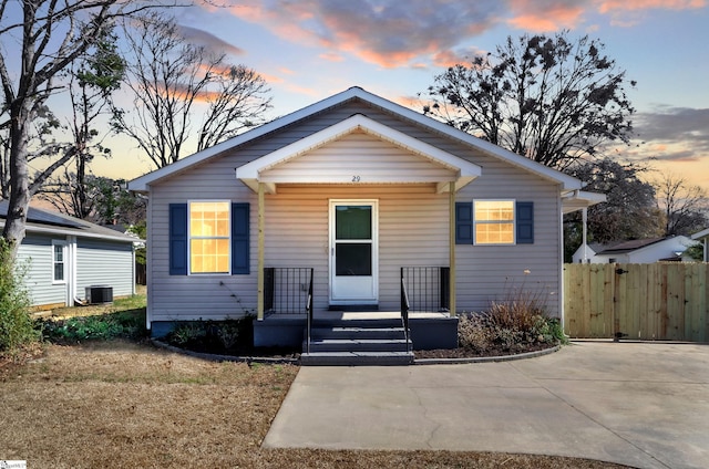 bungalow-style house with a gate, fence, a porch, and cooling unit