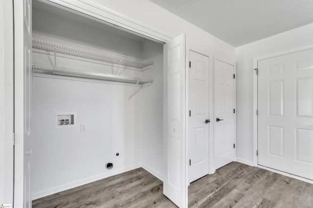 laundry room with washer hookup, laundry area, baseboards, and wood finished floors