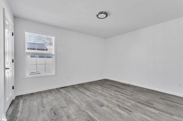 unfurnished room featuring baseboards and wood finished floors