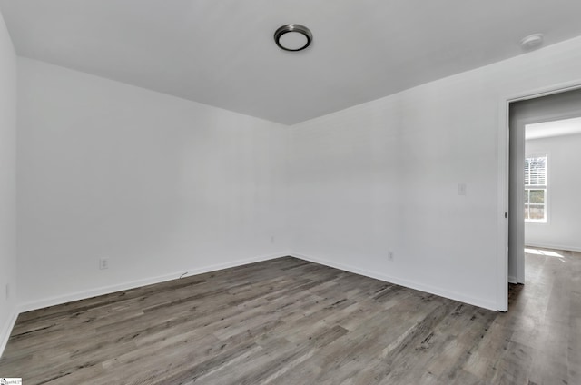 spare room with wood finished floors and baseboards