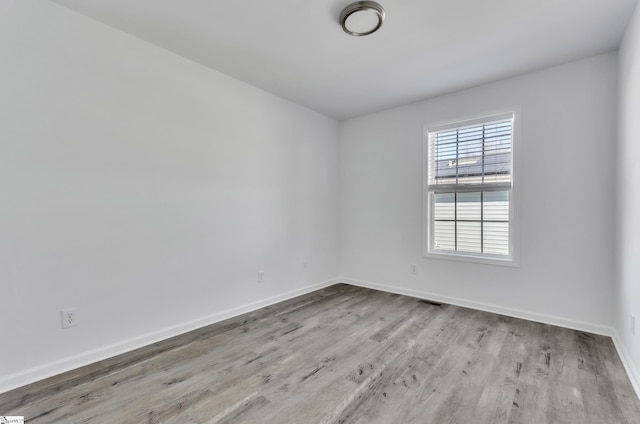 unfurnished room with wood finished floors and baseboards