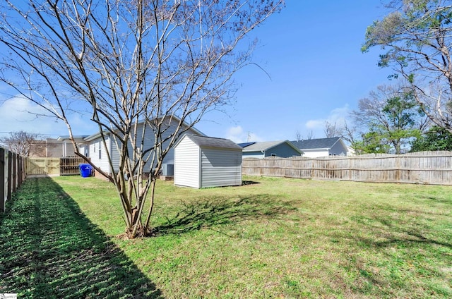 view of yard with a shed, an outdoor structure, and a fenced backyard