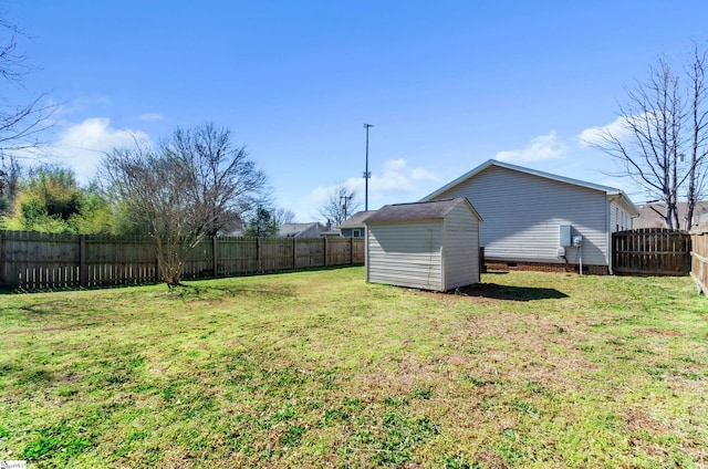 view of yard featuring an outbuilding, a fenced backyard, and a storage shed