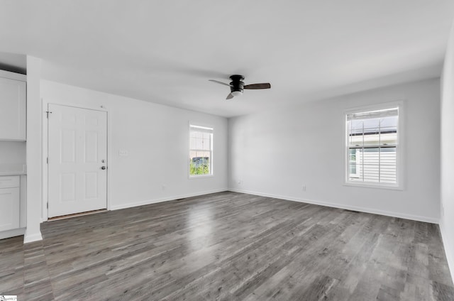 spare room with ceiling fan, baseboards, and wood finished floors