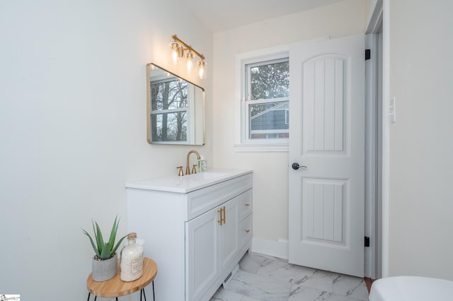 bathroom featuring marble finish floor, vanity, and baseboards