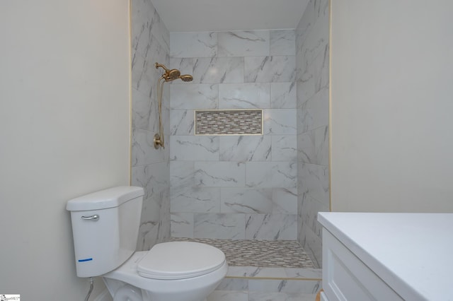 full bath with marble finish floor, tiled shower, vanity, and toilet