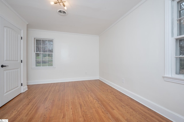 empty room featuring visible vents, crown molding, light wood-style flooring, and baseboards