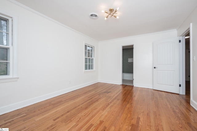 unfurnished bedroom featuring crown molding, visible vents, light wood-style floors, a chandelier, and baseboards