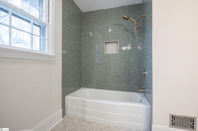 bathroom with baseboards, washtub / shower combination, visible vents, and tile patterned floors