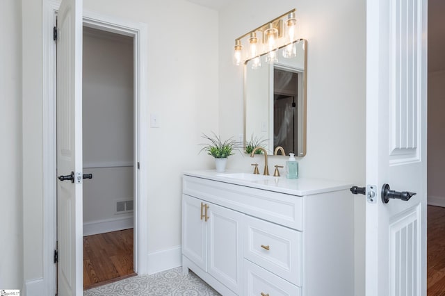 bathroom with vanity, visible vents, and baseboards