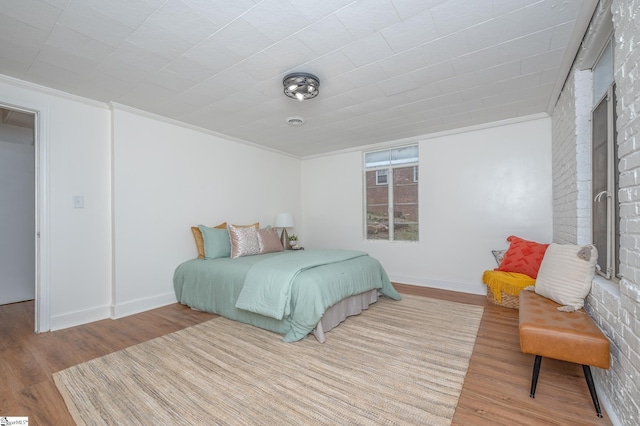 bedroom featuring crown molding, baseboards, and wood finished floors