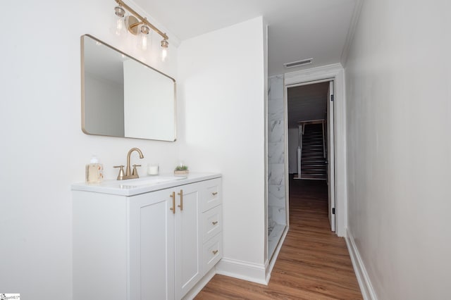 full bath with visible vents, wood finished floors, vanity, and baseboards