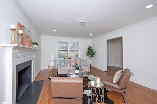 living room featuring baseboards, wood finished floors, visible vents, and crown molding