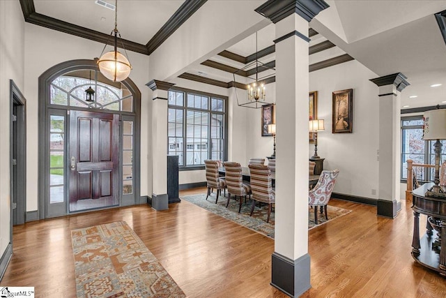 entryway with baseboards, wood finished floors, and ornate columns