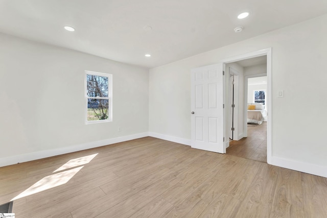 spare room with recessed lighting, light wood-style flooring, and baseboards