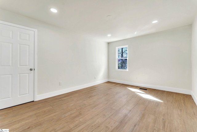 empty room with light wood-style flooring, visible vents, baseboards, and recessed lighting