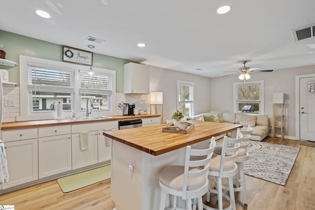 kitchen with butcher block counters, a sink, and visible vents