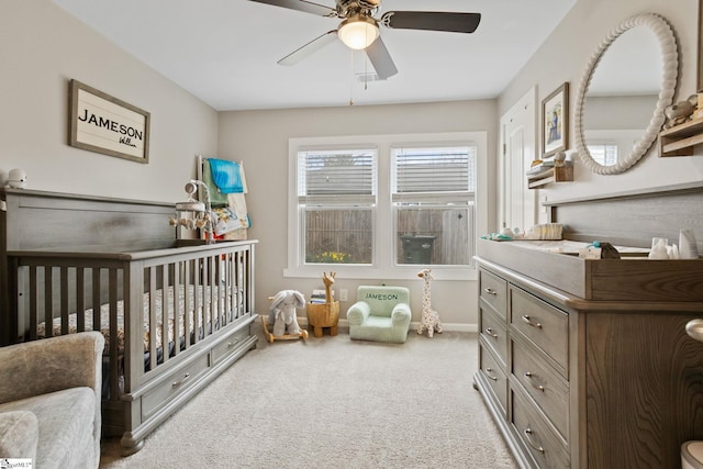 bedroom featuring carpet, baseboards, ceiling fan, and a nursery area