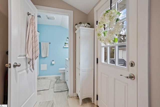 interior space featuring plenty of natural light, visible vents, vaulted ceiling, and baseboards