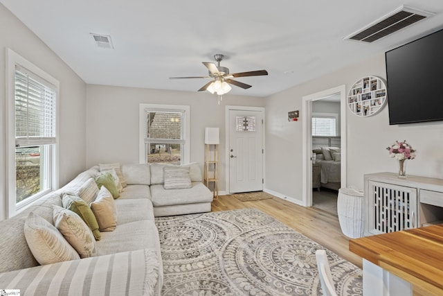 living room with a healthy amount of sunlight, visible vents, and light wood finished floors