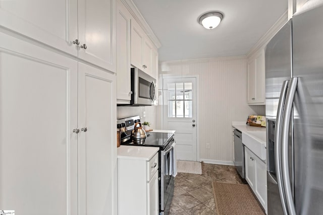 kitchen featuring white cabinetry, appliances with stainless steel finishes, light countertops, and baseboards