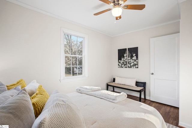 bedroom with ornamental molding, dark wood-type flooring, and a ceiling fan