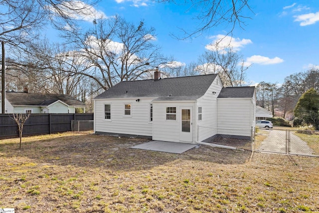 rear view of house with a fenced backyard, a chimney, roof with shingles, a gate, and a yard