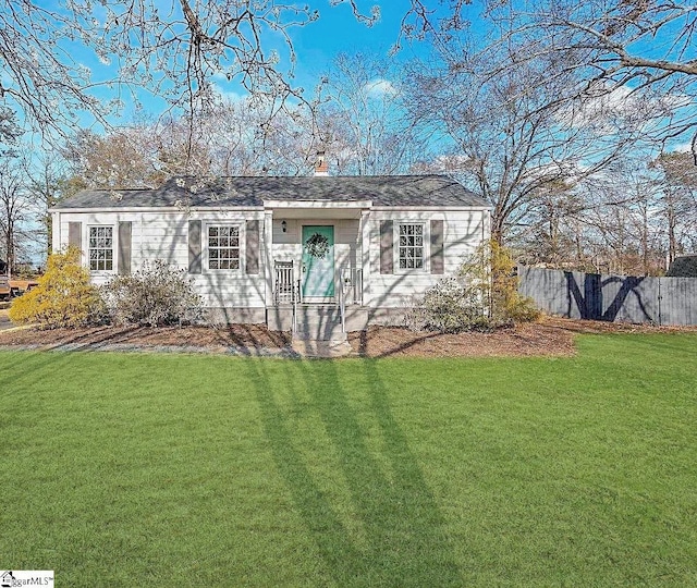 ranch-style home with a front yard and fence