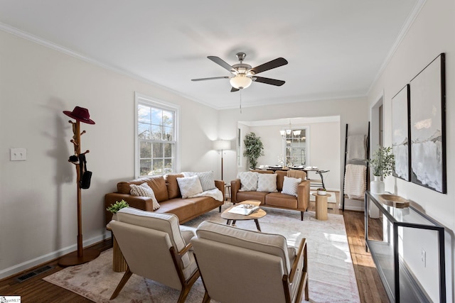 living area featuring ornamental molding, wood finished floors, visible vents, and baseboards