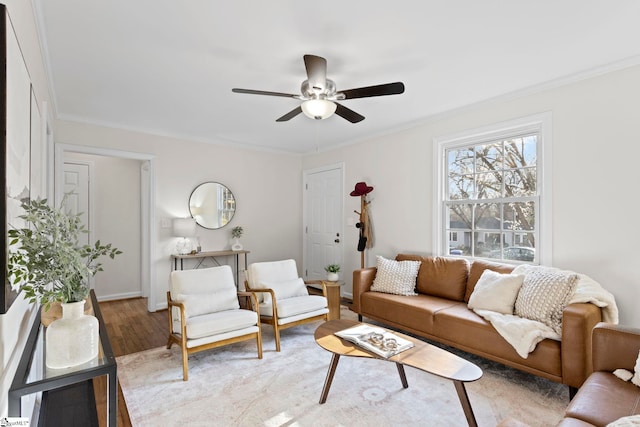 living room with ceiling fan, baseboards, wood finished floors, and crown molding