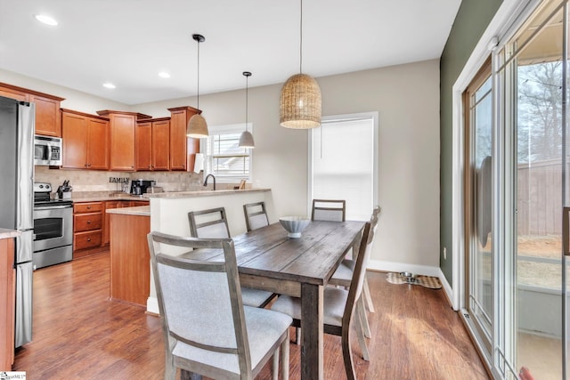 dining room with recessed lighting, wood finished floors, and baseboards