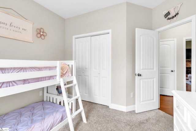 bedroom with light carpet, baseboards, and a closet