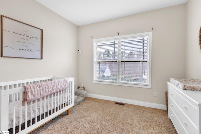 bedroom featuring carpet floors, a nursery area, baseboards, and visible vents