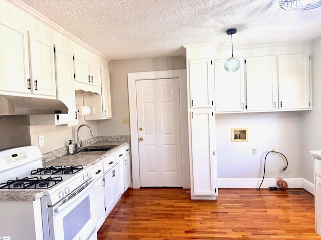 kitchen with under cabinet range hood, a sink, white cabinetry, white gas range oven, and light wood finished floors