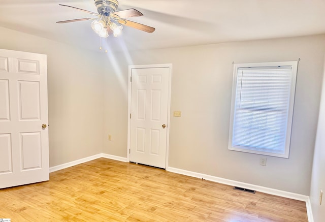 unfurnished bedroom featuring light wood-style flooring, a ceiling fan, visible vents, and baseboards