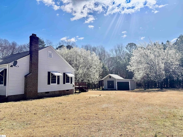 view of yard featuring a garage and an outbuilding