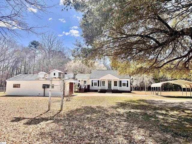 view of front facade with a front yard and a detached carport