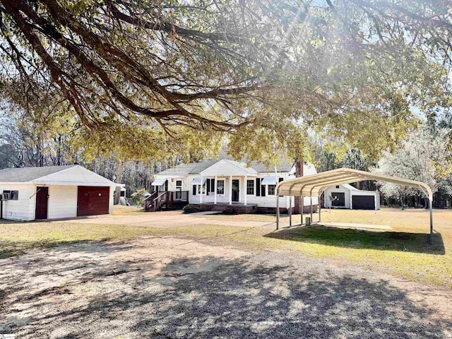 view of front of home with a carport, an outbuilding, and a front lawn