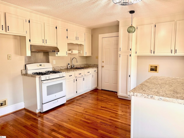 kitchen featuring under cabinet range hood, wood finished floors, a sink, white cabinetry, and white gas range oven