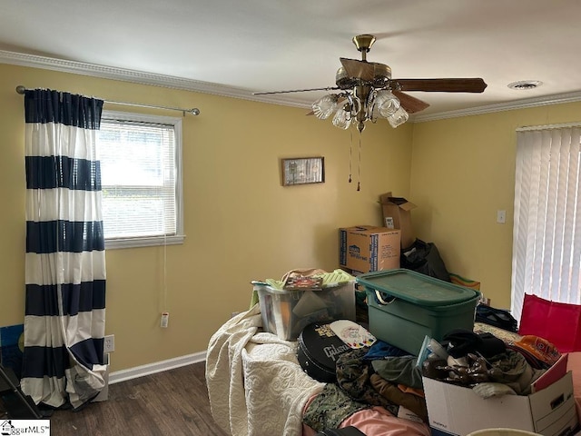 bedroom featuring wood finished floors, a ceiling fan, visible vents, baseboards, and ornamental molding