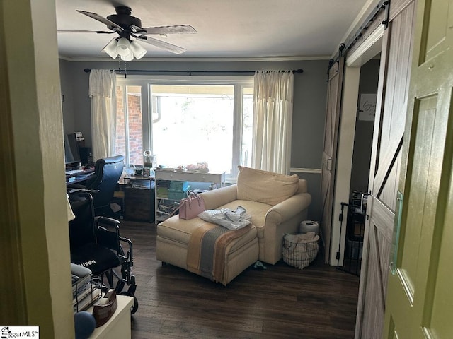 home office featuring ceiling fan, wood finished floors, crown molding, and a barn door