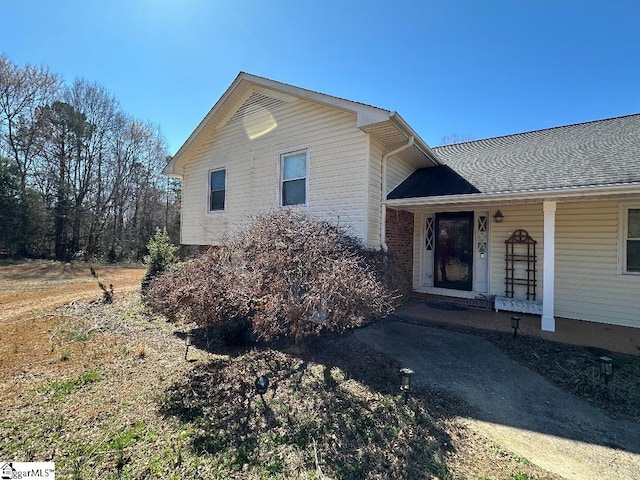 view of front of property featuring covered porch and roof with shingles