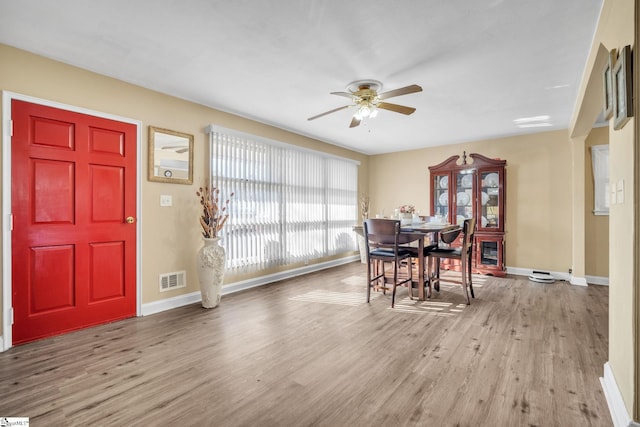 dining room featuring wood finished floors, visible vents, and baseboards