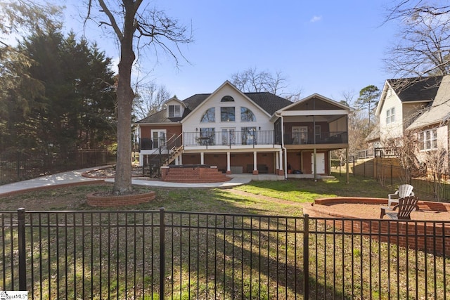 back of property featuring a lawn, a patio, a sunroom, a fenced front yard, and stairway