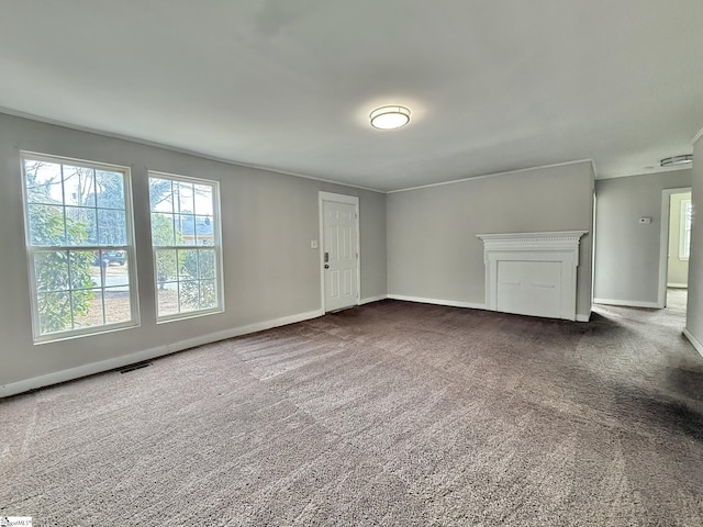 empty room with dark carpet, visible vents, and baseboards