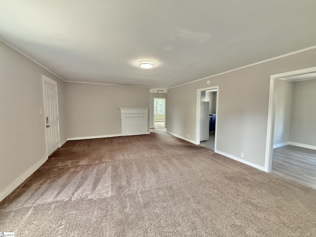 carpeted empty room with crown molding and baseboards