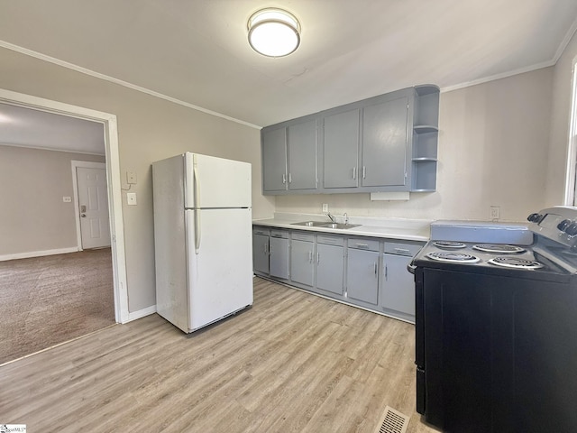 kitchen featuring crown molding, black electric range oven, gray cabinetry, freestanding refrigerator, and a sink