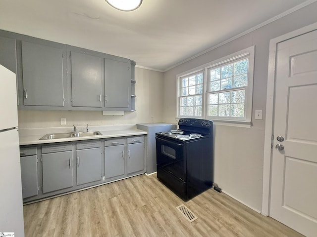 kitchen featuring light wood-style flooring, electric range, gray cabinetry, ornamental molding, and a sink